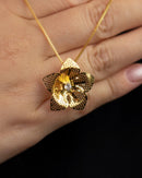 Colar Dourado com Pingente de Flor Trabalhada em Camadas e Cristal Central